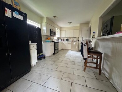 Kitchen featuring white cabinetry and electric ran