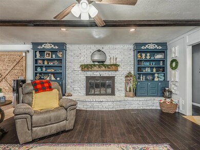 Living room featuring a brick fireplace, dark hard