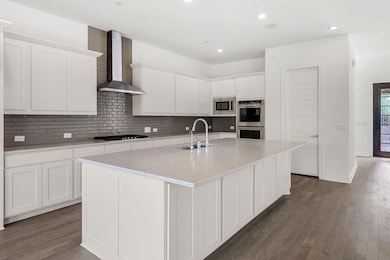 Kitchen with a sink, wall chimney range hood, app