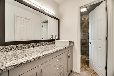 Bathroom with tiled shower, vanity, tile patterned