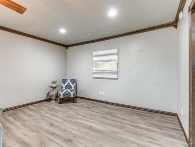 Unfurnished room with crown molding and light wood-type flooring