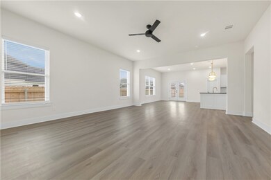 Unfurnished living room featuring a ceiling fan, l