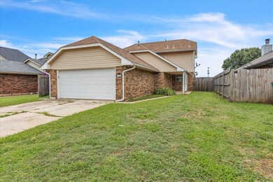 View of front facade with an attached garage, brick siding, and driveway