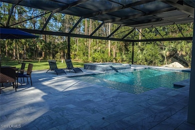 View of pool featuring glass enclosure, a pool wit
