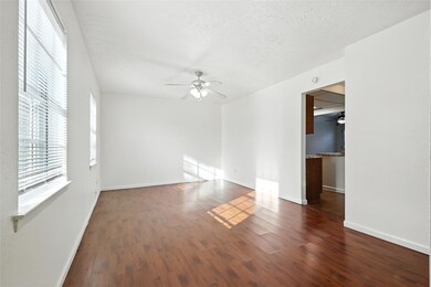 Living room with ceiling fan, wood finished floors, and a textured ceiling
