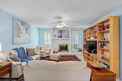 Living room with a textured ceiling, a ceiling fa