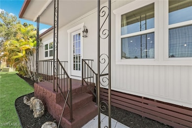 View of exterior entry with a porch, a lawn, and r