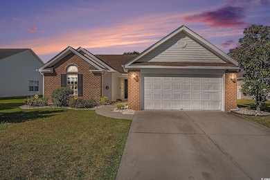 Single story home featuring driveway, brick siding, and a lawn