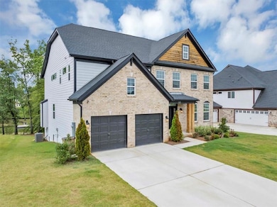 View of front of house with concrete driveway, a garage, brick siding, and a front lawn
