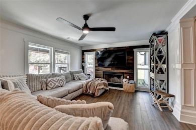 Living room with crown molding, a fireplace, dark 