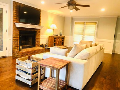 Living room with a brick fireplace, dark hardwood 