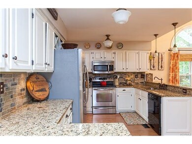 Kitchen features granite counters, slate backsplas