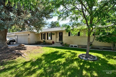 Single story home with an attached garage, brick siding, a front lawn, and concrete driveway