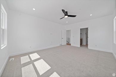 Unfurnished bedroom featuring light carpet, recessed lighting, ceiling fan, and connected bathroom