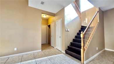 Stairway featuring baseboards, tile patterned floo