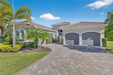 Mediterranean / spanish house with a gate, stucco siding, decorative driveway, and a tile roof