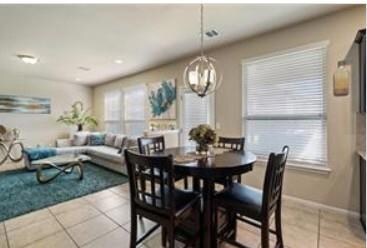 Dining area featuring light tile patterned floors and a chandelier