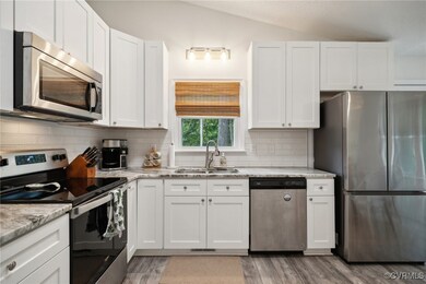 Kitchen with vaulted ceiling, appliances with stai