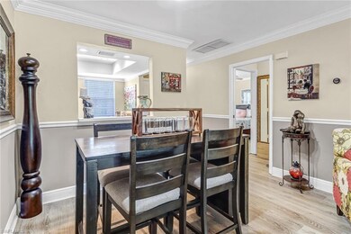 Dining area featuring a raised ceiling, ornamental