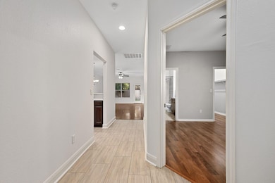 Corridor featuring wood tiled floors, a textured wall, and recessed lighting
