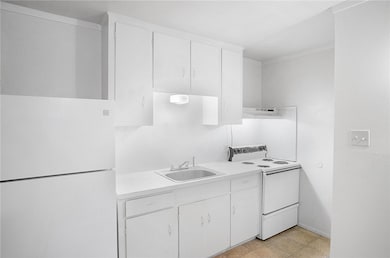 Kitchen featuring white cabinetry, sink, and white