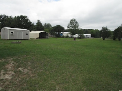 View of green lawn with a detached carport