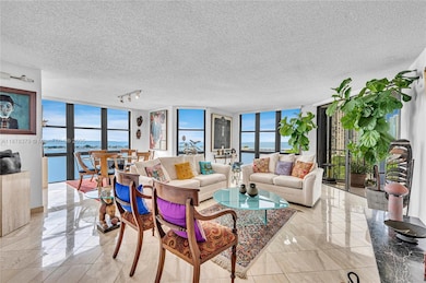 Open living room and dining room with open views of Biscayne Bay, Key Biscayne and Rickenbacker Bridge.  Views are to the east and south.