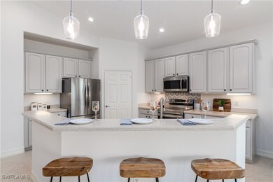 Kitchen with an island with sink, baseboards, a ki