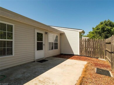 Fully fenced in backyard patio with storage building!