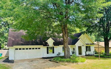 View of front of home with a shingled roof, a garage, driveway, and brick siding