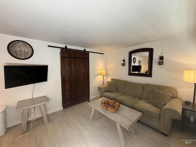 Living room featuring a barn door and light wood-style flooring