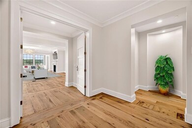 An inviting corridor framed by double doors leads to a bright, open living space with stunning natural light and expansive views.