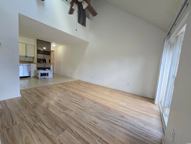Unfurnished living room featuring ceiling fan, vau