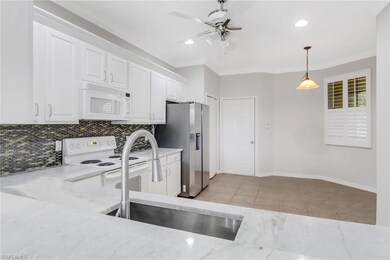 Kitchen with white appliances, a sink, backsplash,