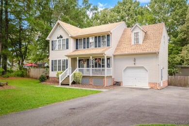 View of front of house with a front yard, a garage, and a porch