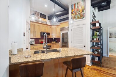 Kitchen featuring stainless steel appliances, light brown cabinets, light wood-style floors, a peninsula, and backsplash