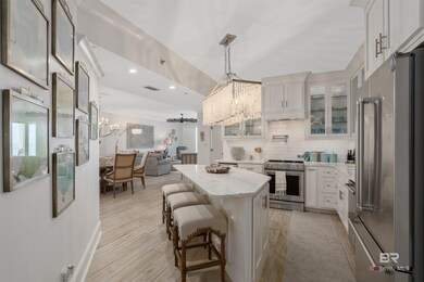 Kitchen with white cabinets, a breakfast bar, an inviting chandelier, hanging light fixtures, and premium appliances