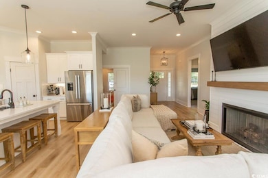 Living room with crown molding, a ceiling fan, light wood-style floors, plenty of natural light, and recessed lighting