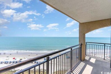 Balcony featuring a water view and a beach view