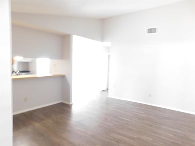 Unfurnished room featuring dark wood-type flooring and high vaulted ceiling