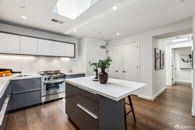 Modern kitchen featuring quartz countertops, stainless appliances, and a sunlit breakfast bar.