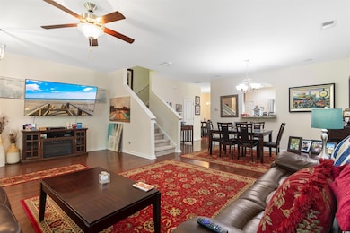 Living room with ceiling fan with notable chandeli
