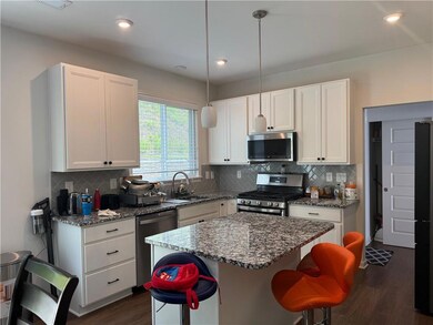 Kitchen with stainless steel appliances, a sink, dark stone countertops, white cabinets, and recessed lighting