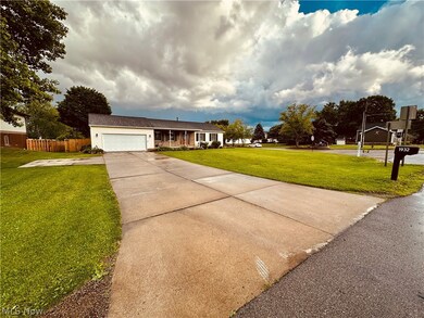 Ranch-style home with a garage and a front lawn