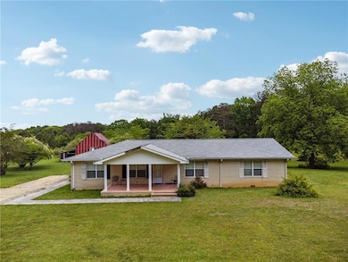 Back of property featuring a lawn and brick siding