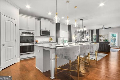 Kitchen featuring ceiling fan, a center island with sink, stainless steel appliances, and plenty of natural light