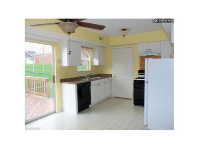 Bright cheery kitchen with range, refridgerator an