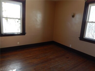 Empty room featuring plenty of natural light and dark wood-type flooring