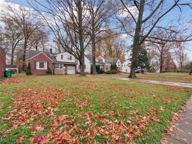 View of grassy yard featuring a garage, a residential view, and driveway