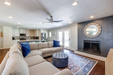 Living area featuring a fireplace, wood finished floors, recessed lighting, crown molding, and a ceiling fan